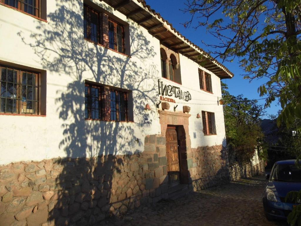 a white building with a sign on the side of it at Inka Tambo Hacienda in Cusco