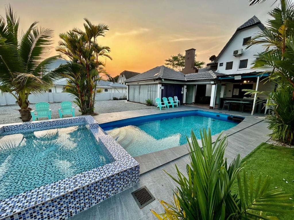 basen z krzesłami i dom w obiekcie A famosa resort villa 1054 w mieście Kampong Alor Gajah