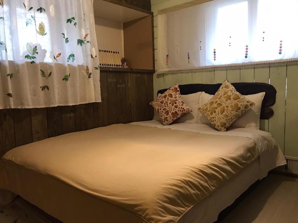 a bed with pillows on it in a bedroom at A-HOME in Jiufen