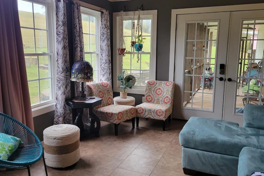 a living room with a couch and chairs and windows at Flatt Creek Cottage in Livingston