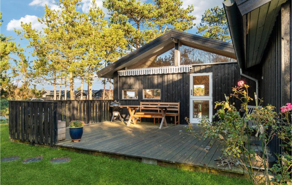 een huis met een houten terras met een tafel bij Beautiful Home In Sams With Kitchen in Nordby