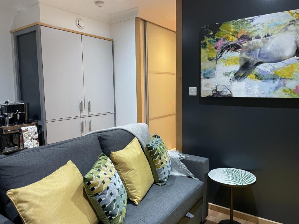 a living room with a couch and a painting on the wall at Chic Citispace -1-Bed Apartment Leeds City-WiFi in Leeds