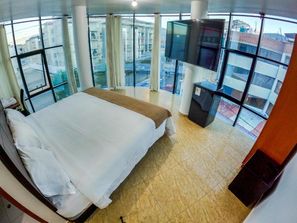 1 dormitorio con 1 cama en una habitación con ventanas en HOTEL REAL PLAZA, en Cajamarca