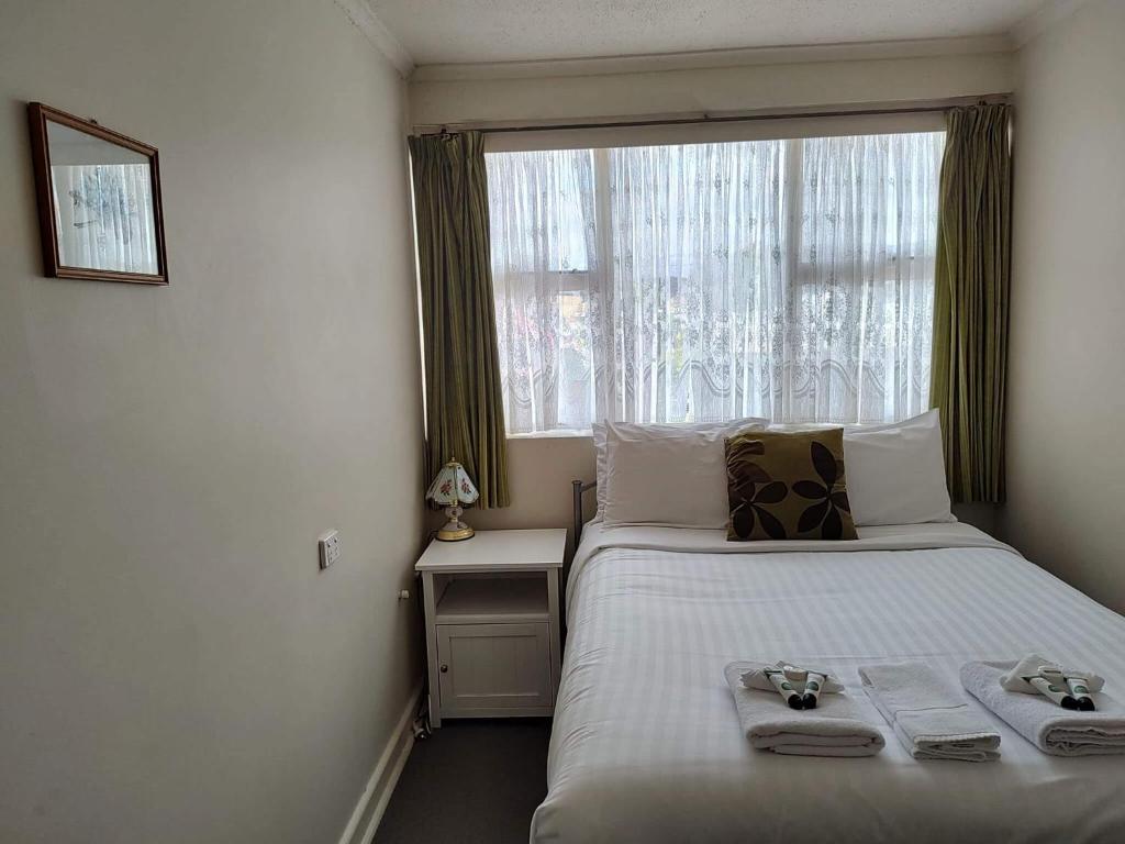 a bedroom with a bed with towels and a window at Lachlan Hotel 