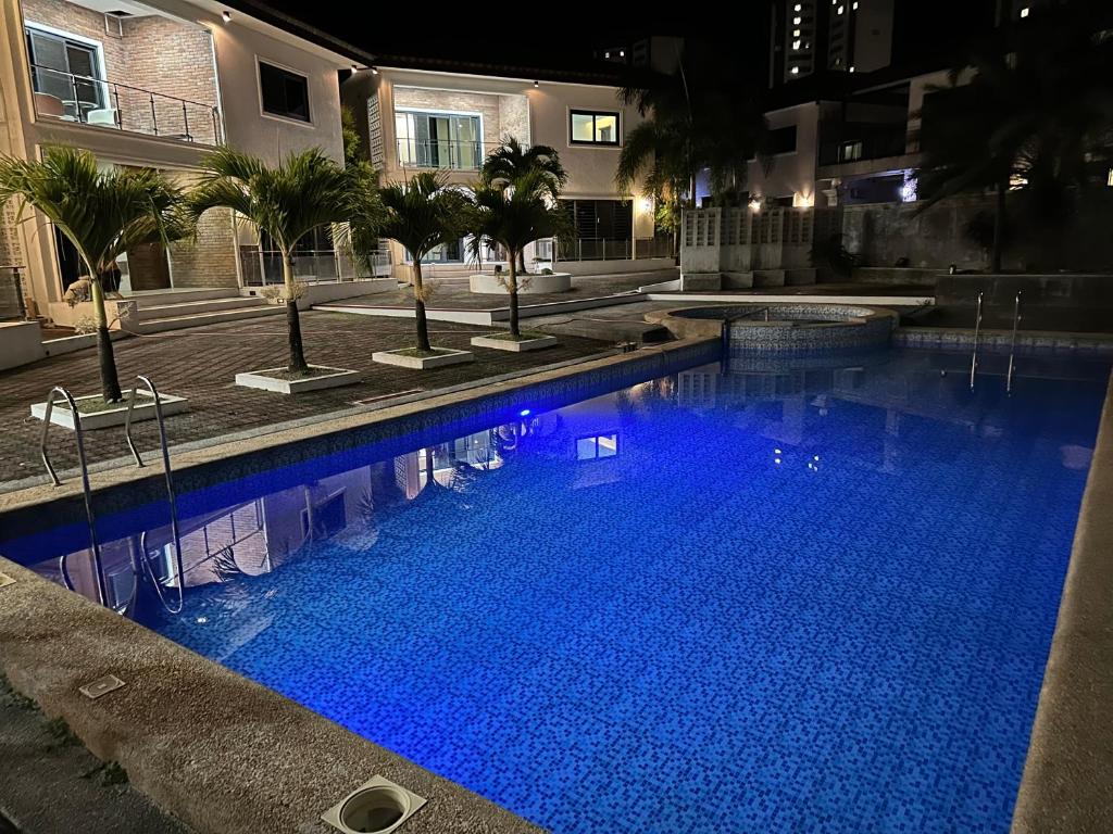 una gran piscina de agua azul por la noche en S Pool Villa Clark 天天别墅酒店 en Ángeles