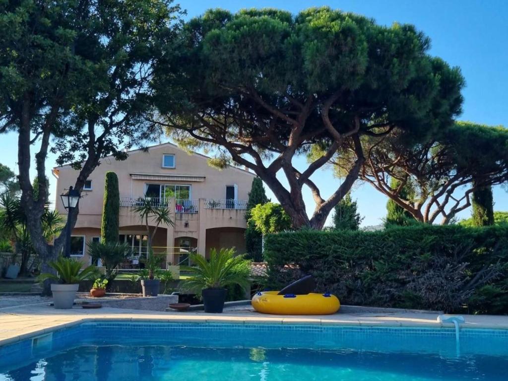 une maison et une piscine avec un bateau jaune devant elle dans l'établissement Sainte Maxime Sémaphore : Haut de Villa T4, Piscine, Terrasse, Clim, Proche Mer - FR-1-226-531, à Sainte-Maxime