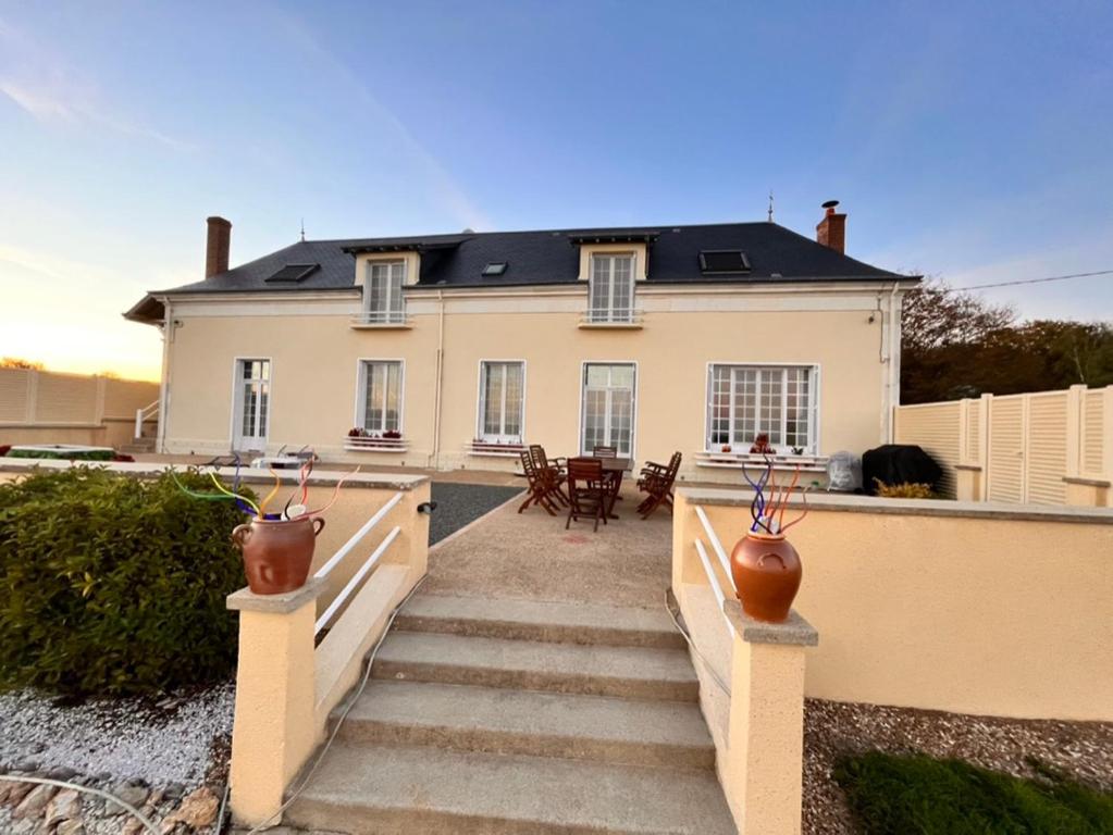 una gran casa blanca con escaleras delante en Mon "Chateau" FRAUSSIE, en Chahaignes