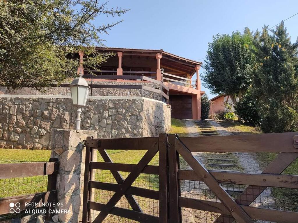 a wooden gate with a fence in front of a house at Chalet Fer Icho in Villa Icho Cruz