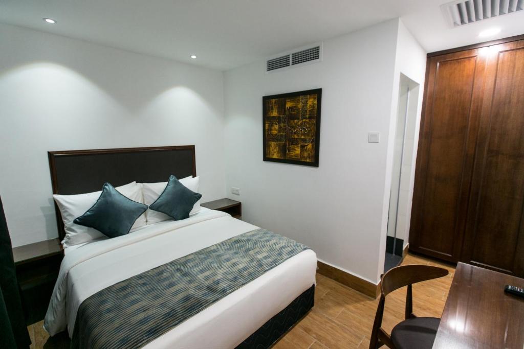 Postel nebo postele na pokoji v ubytování Belllo Hotel JB Central
