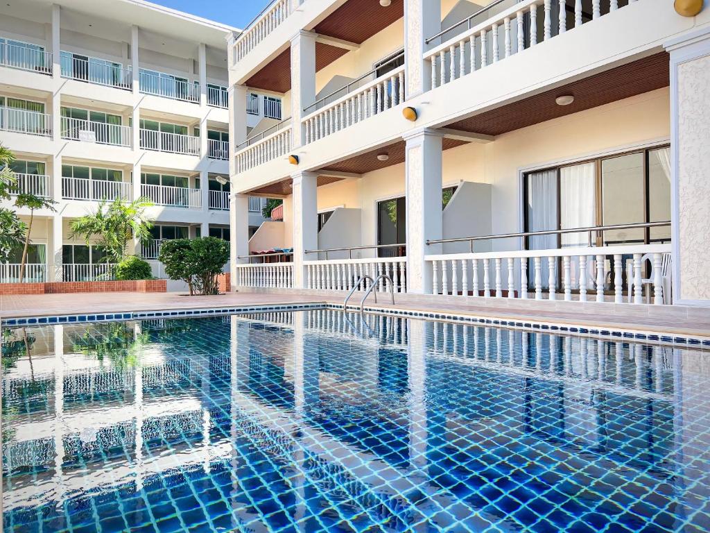 a swimming pool in front of a building at Tri's Miracle Kata Beach Side in Kata Beach