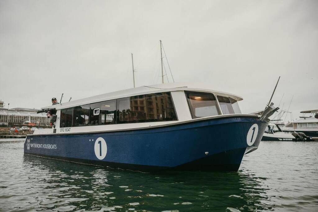 Ein blaues Boot sitzt im Wasser in der Unterkunft Waterfront Houseboat in Kapstadt