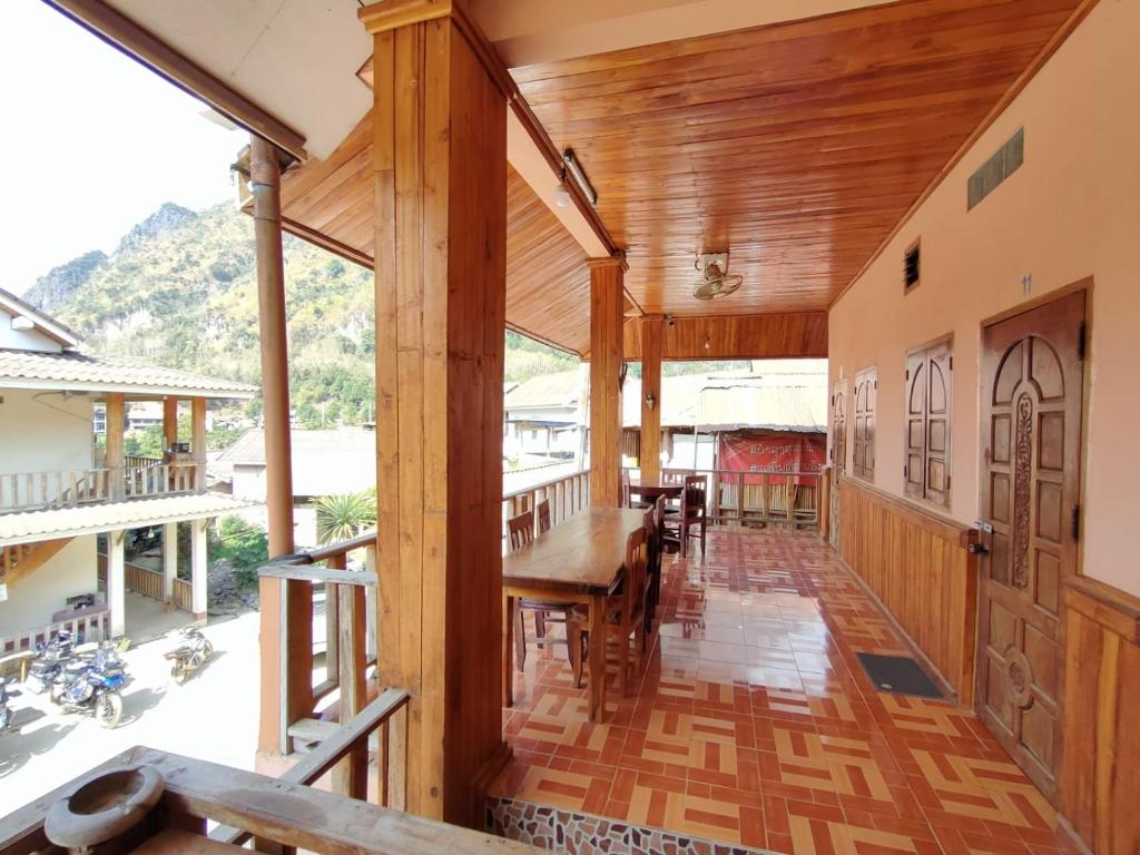 Un comedor con mesa y sillas en un balcón. en phoulisack guesthouse, en Ban Sôphoun