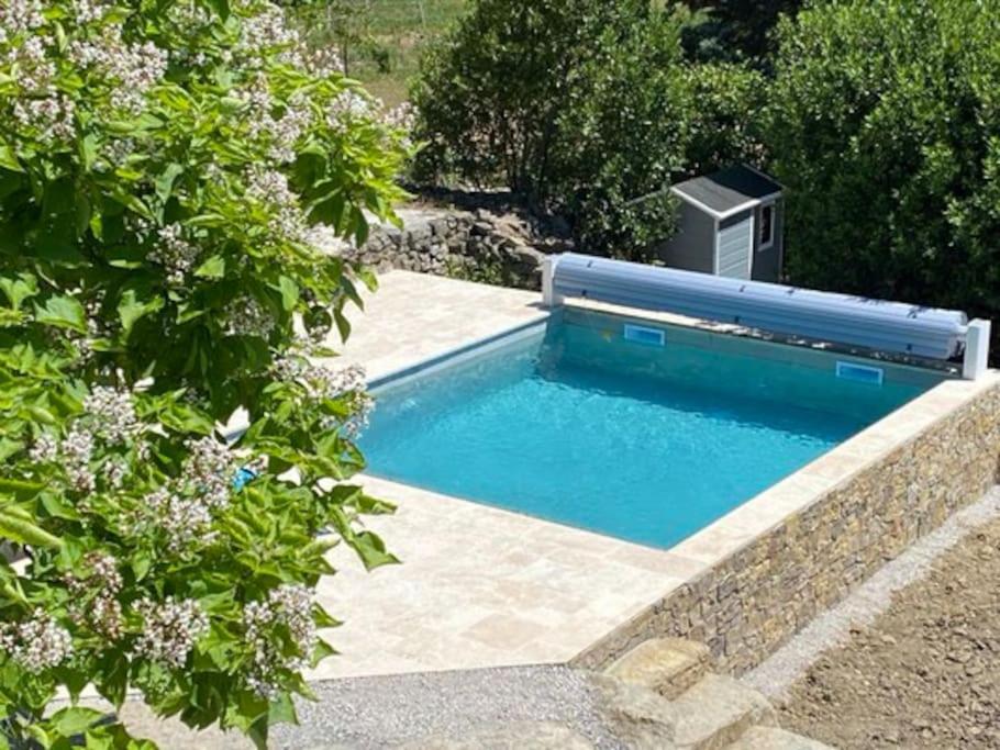 uma piscina com uma fonte num jardim em Gite Oustalet avec piscine & SPA em Générargues