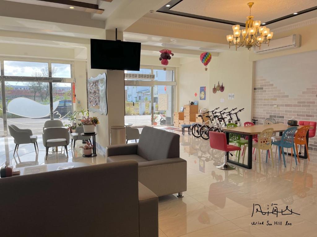 a living room with a couch and a table and chairs at Wind Sea Hill Inn in Hengchun South Gate