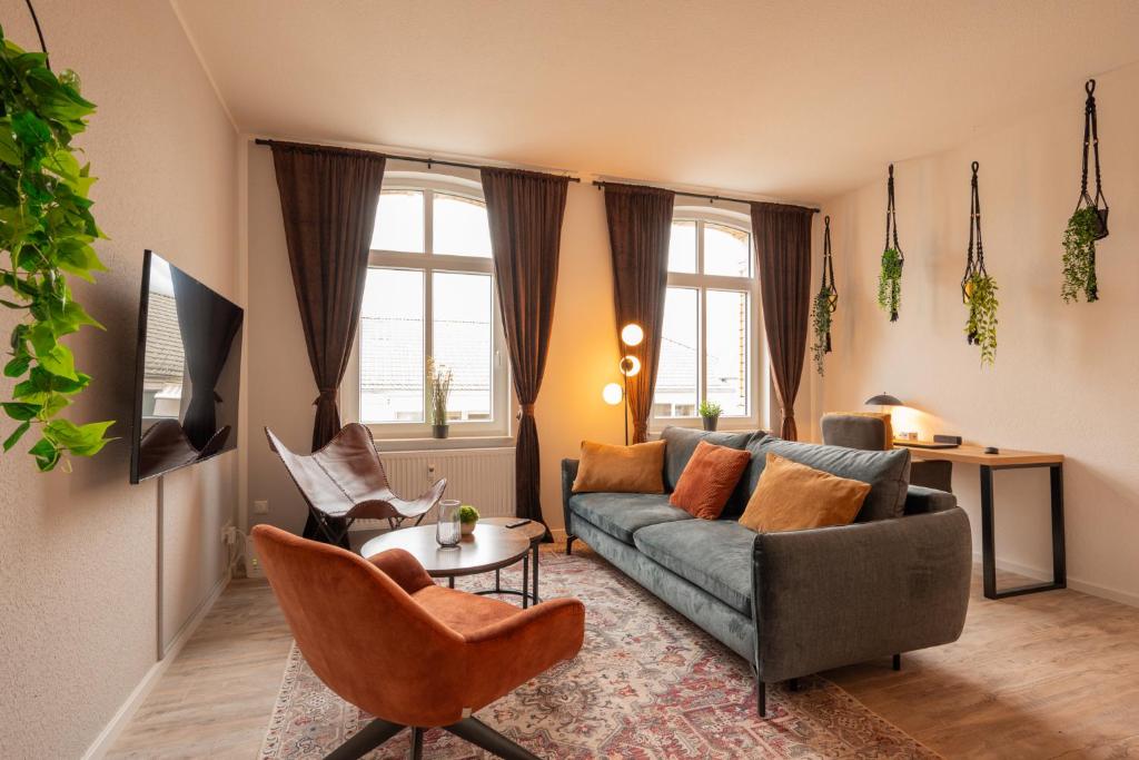 maremar - Style Apartment im Zentrum - Luxus Boxspringbett - Arbeitsplatz - Highspeed WLAN في غيرا: غرفة معيشة مع أريكة وطاولة