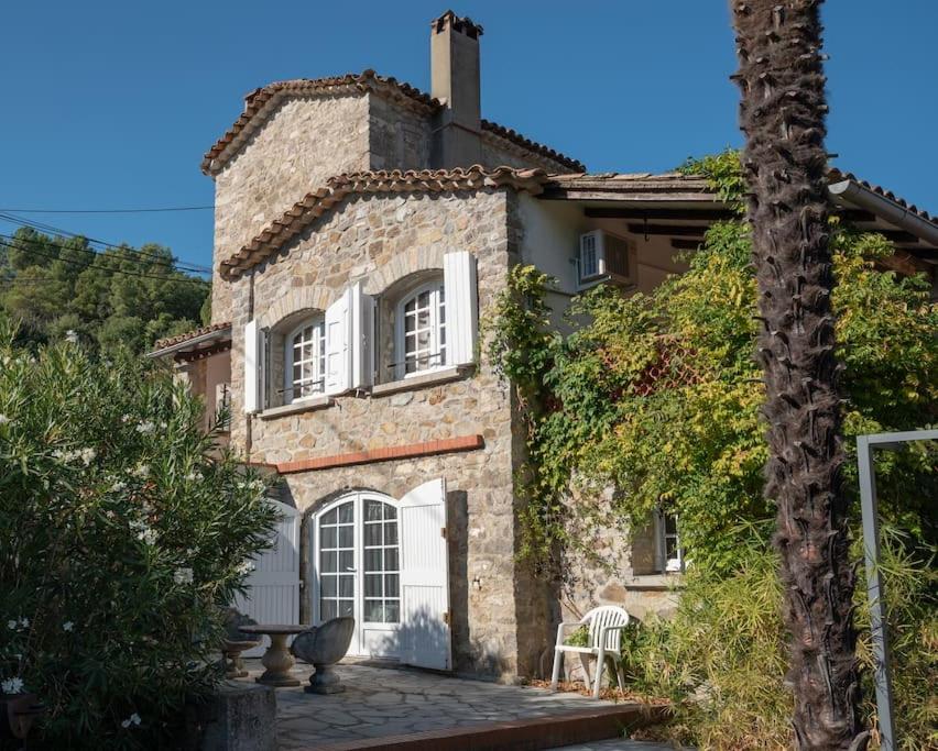 Casa de piedra con puerta blanca y ventanas en Gite l'Ortal avec piscine & SPA, en Générargues