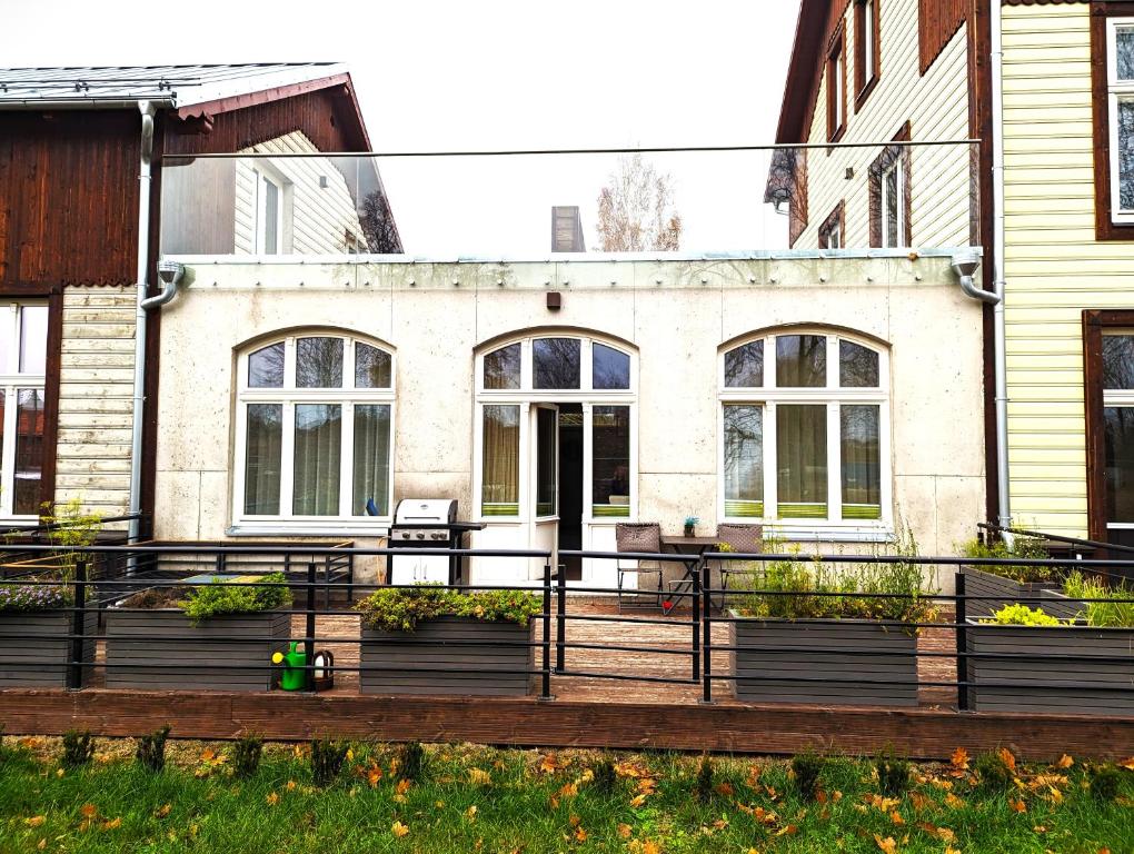 ein Haus mit einer Veranda mit Pflanzen davor in der Unterkunft Sissi Apartment Aleksandri 32 in Tartu