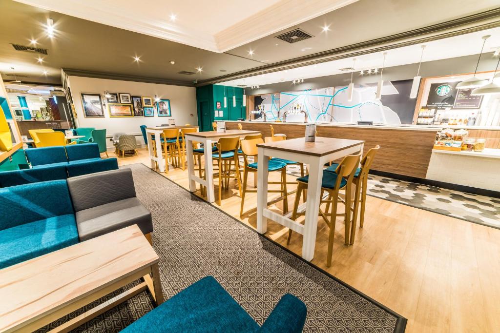 ein Restaurant mit blauen Möbeln und einer Bar in der Unterkunft Holiday Inn Leeds Brighouse, an IHG Hotel in Brighouse
