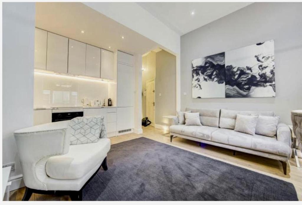 sala de estar con sofá, sofá y mesa en Stylish Apartment in the heart of Chelsea en Londres