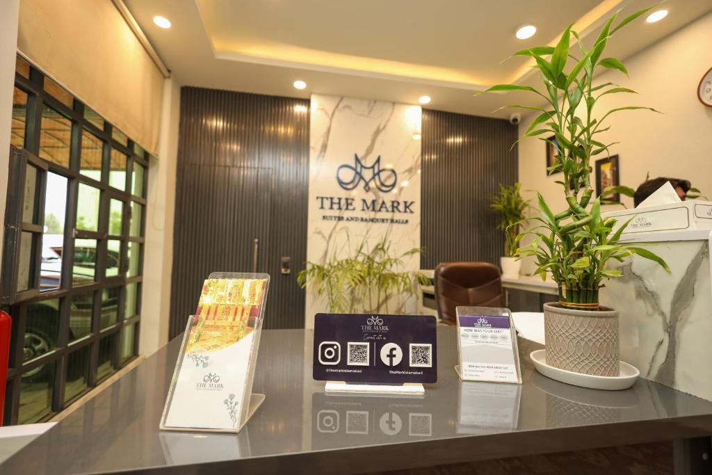 a lobby with a counter with plants on it at The Mark in Islamabad