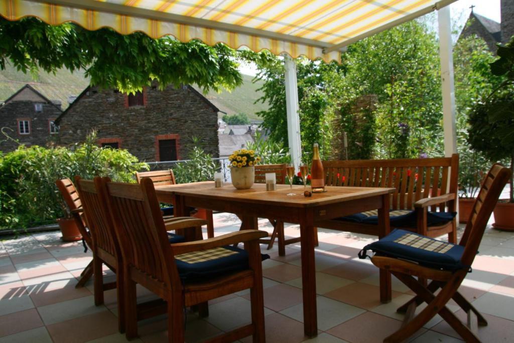 einen Holztisch und Stühle auf einer Terrasse in der Unterkunft Weingut & Gästehaus Stephan Kohl in Neumagen-Dhron