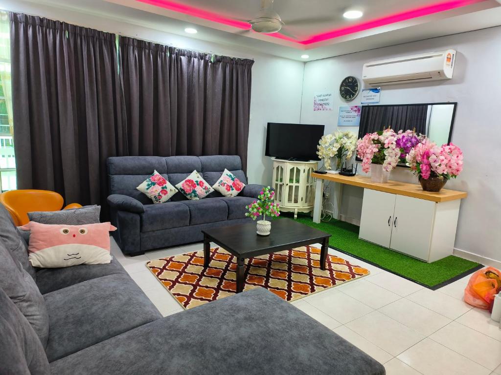 a living room with two couches and a television at Trails of Kampar Villa Homestay in Kampar