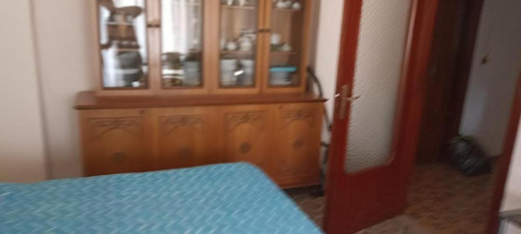 Zimmer mit einem Holzschrank und einem blauen Tisch in der Unterkunft Avellino camera matrimoniale CENTRALISSIMA in Avellino