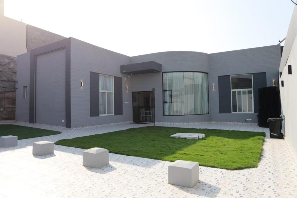 a large house with a yard with a grass at شاليهات صن سيت تايم in Khamis Mushayt