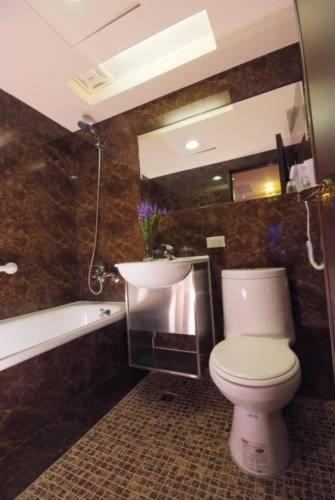 a bathroom with a toilet and a sink and a tub at Lio Hotel - Taipei Main Station in Taipei