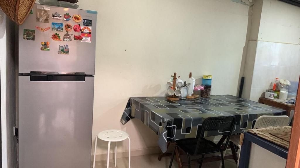 a kitchen with a refrigerator and a table with chairs at Berkat Pak Raja Homestay Mergong Alor Setar 