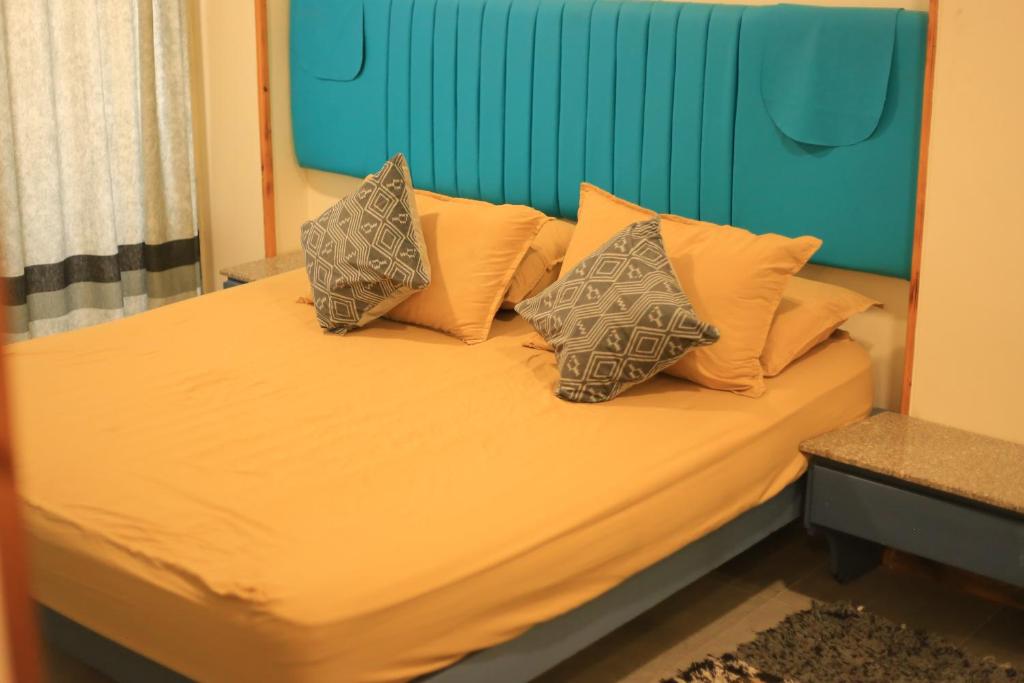 a bed with four pillows on top of it at heart of town sea view in Safaga