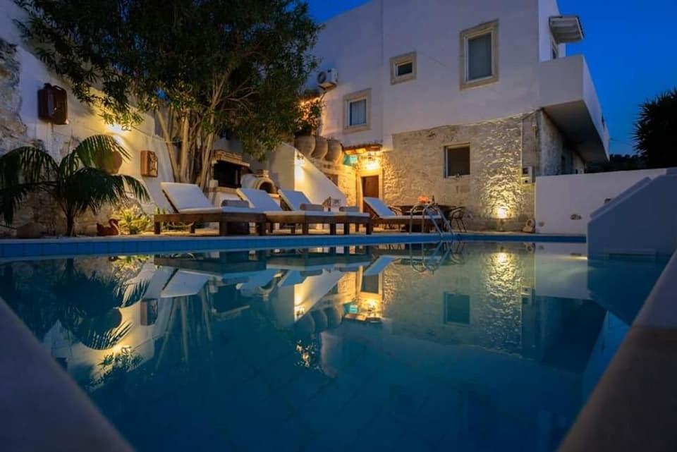 une villa avec une piscine la nuit dans l'établissement Holiday Apartment Agapi, à Kamilárion