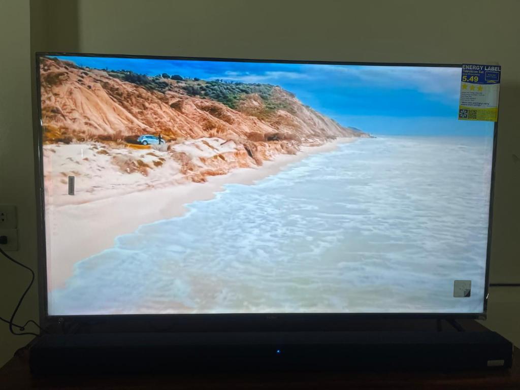 uno schermo televisivo con foto di una spiaggia di Maria Kulafu Kubo House 1 BIG BEDROOM with Wifi a Masbate