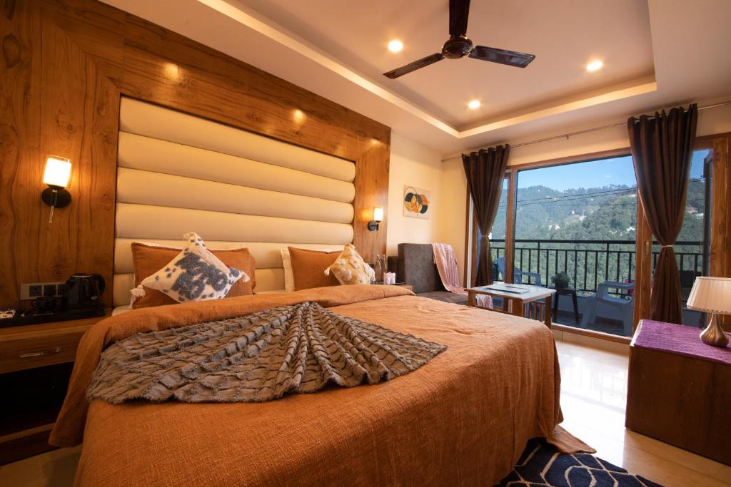 a bedroom with a large bed and a balcony at PerfectStayz Mall Road Mussoorie in Mussoorie