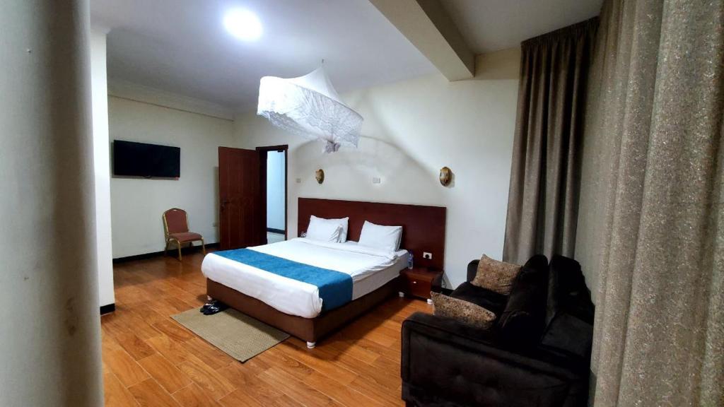 バハルダールにあるYiganda Hotel - Ethiopiaのベッドとソファ付きのホテルルーム
