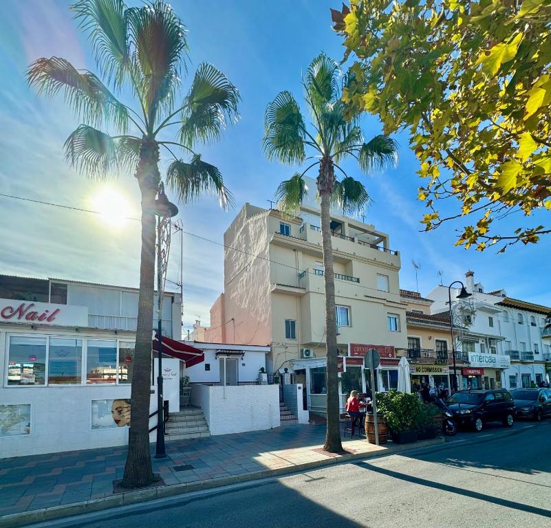 eine Straße mit Palmen vor einem Gebäude in der Unterkunft CASA EN PLENO CENTRO DE LA CALA DE MIJAS by Holidays2Rent in La Cala de Mijas