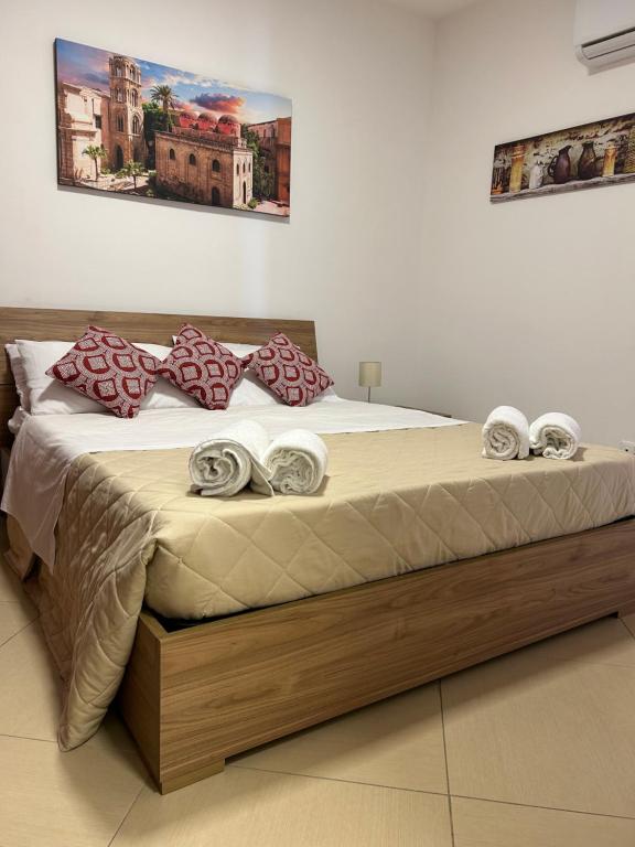 a bedroom with a large bed with a wooden frame at Vicolo Appalto Apartment in Palermo