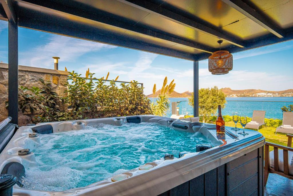 a hot tub on a patio with a view of the ocean at Çimentepe Residence Deluxe 2 - Villa with Jacuzzi in Yalikavak in Bodrum City