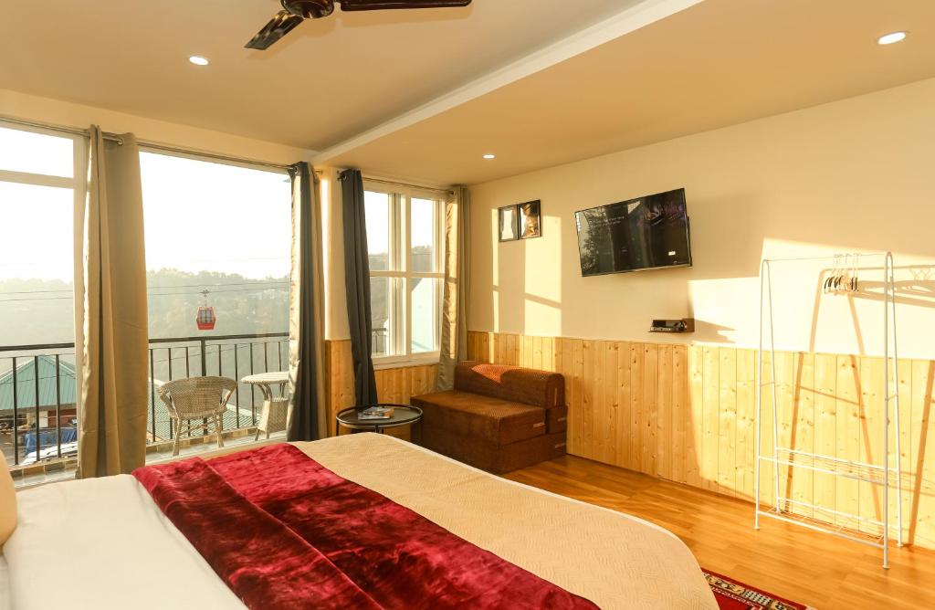 1 dormitorio con 1 cama grande y balcón en Himalayan Suite, en Dharamshala
