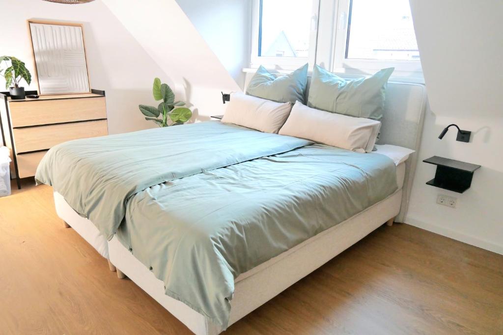 een slaapkamer met een groot bed met blauwe lakens en kussens bij Ferienhaus Anni & Fritz in Goslar