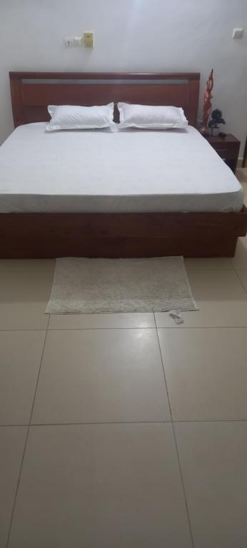 una cama en la parte superior de un suelo blanco en Résidences Hôtel Perle Bleue en Cotonú