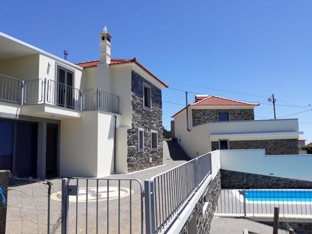 a villa with a swimming pool and a house at Quinta Escola in Arco da Calheta