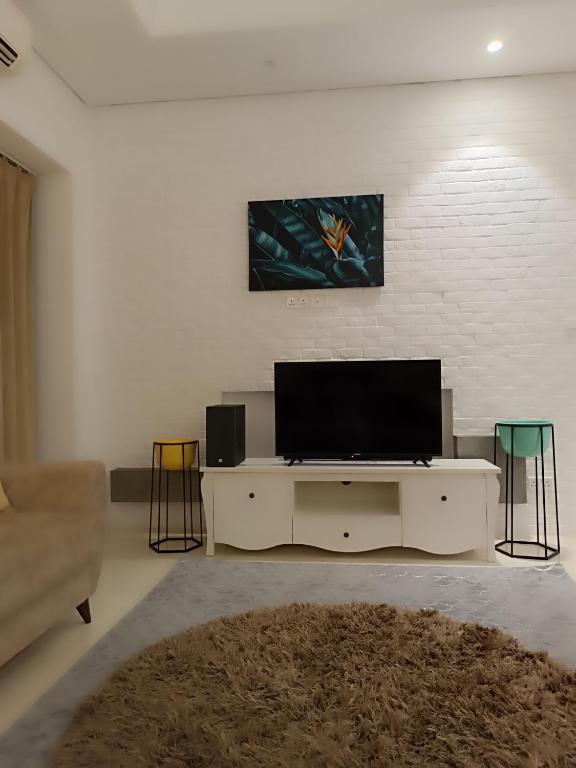 a living room with a flat screen tv on a wall at Sunsetserenade in Ţāqah