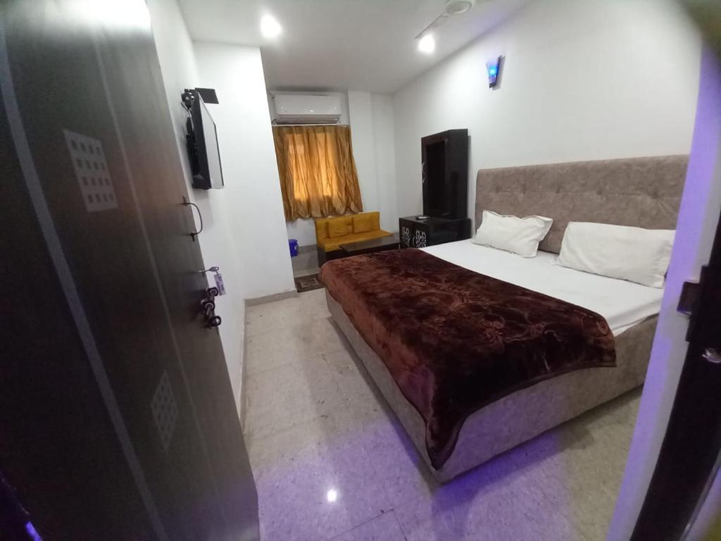 a bedroom with a large bed and a television at Metro Regency Near Lucknow Junction- Couple Friendly Hotel in Lucknow