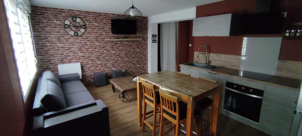 eine Küche und ein Wohnzimmer mit einem Tisch und einem Sofa in der Unterkunft Au Terrier in Bettancourt-la-Ferrée
