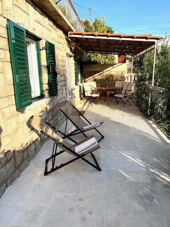 a patio with a table and chairs and a building at Garden Apartment in Selca