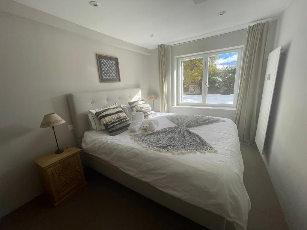 a bedroom with a white bed with a window at Verbier Apt 2 rooms (3 guests) in Verbier