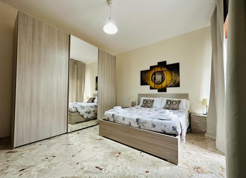 um quarto com uma cama e um espelho grande em B&B - Piazza Grande em Gela