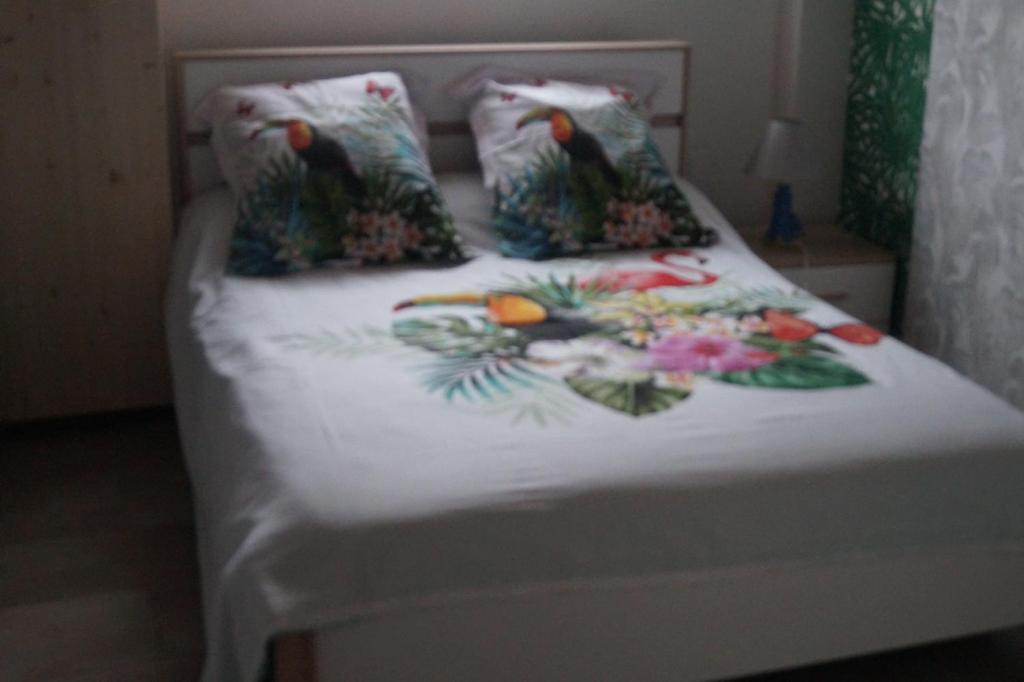 Una cama con un edredón blanco con pájaros. en Repos en campagne, en Pexiora