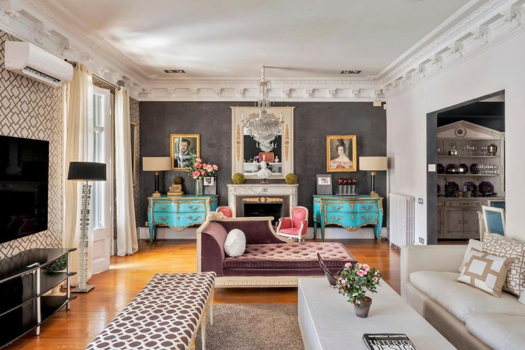 HoHomes - Luxury Palacete في برشلونة: غرفة معيشة مع أريكة ومدفأة